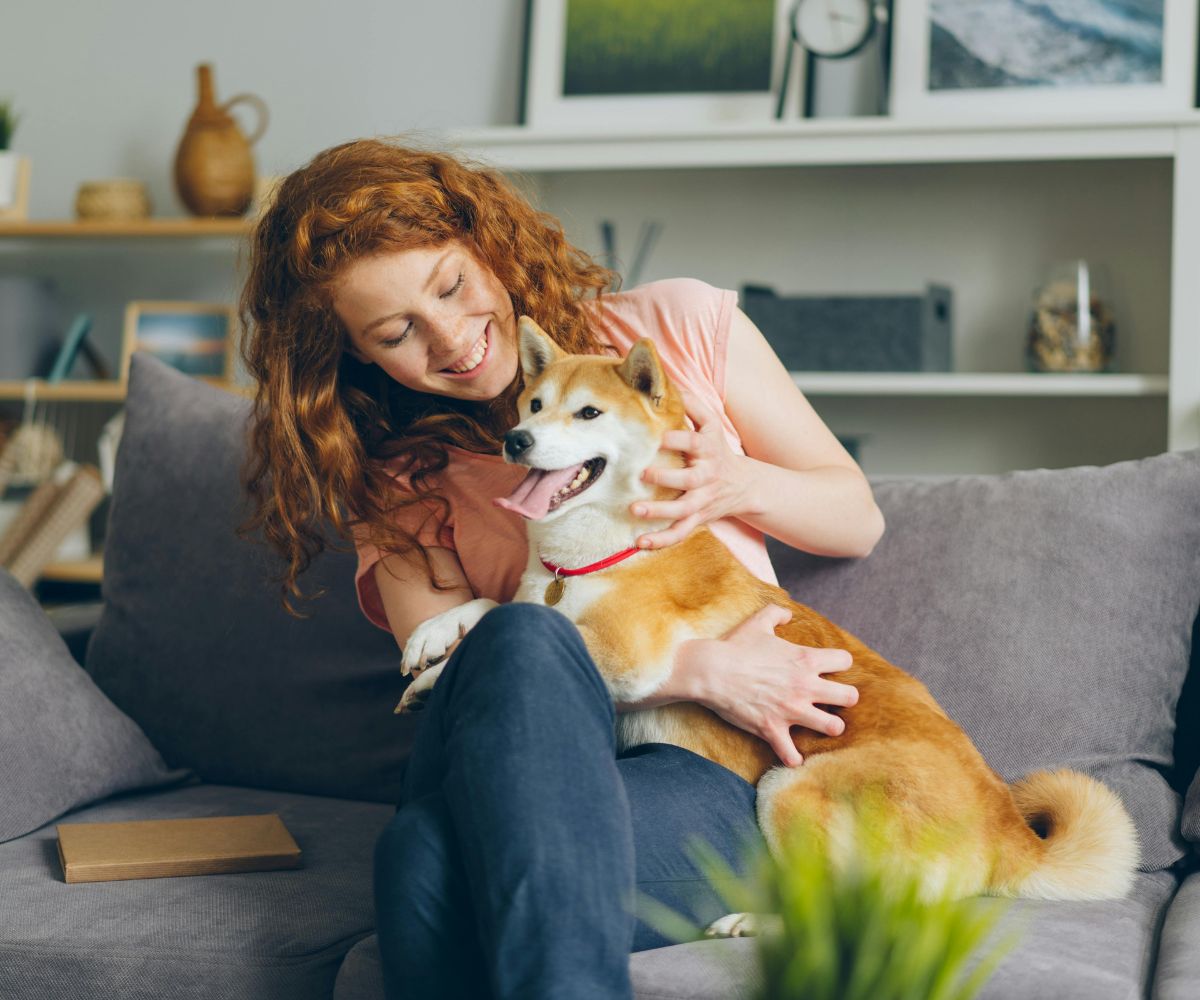 happy-golden-retriever-dog-lying-on-living-room-floor-1200x1000-1 A woman and her dog sit together on a couch