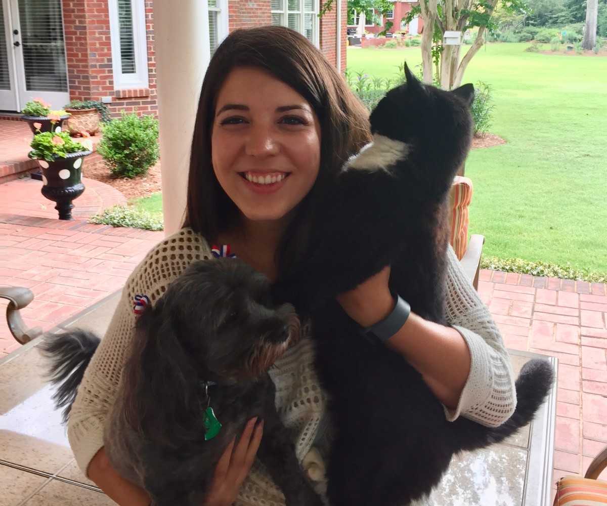 A woman embraces a cat and dog a woman embraces a cat and dog